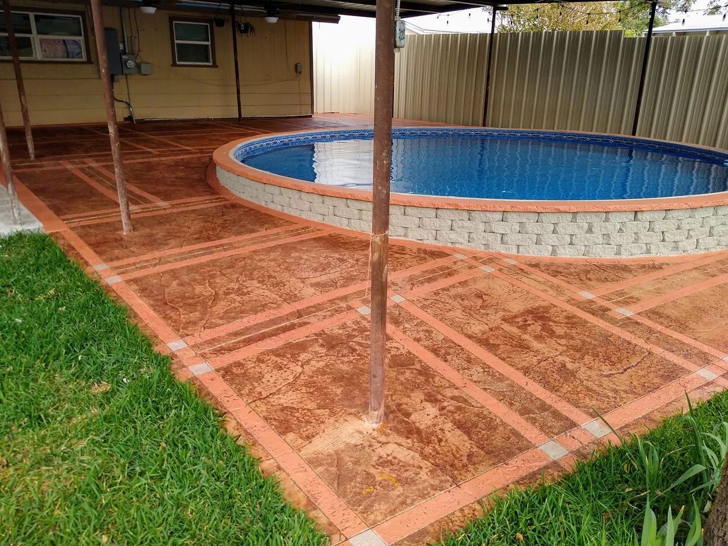 a large swimming pool is surrounded by a brick walkway