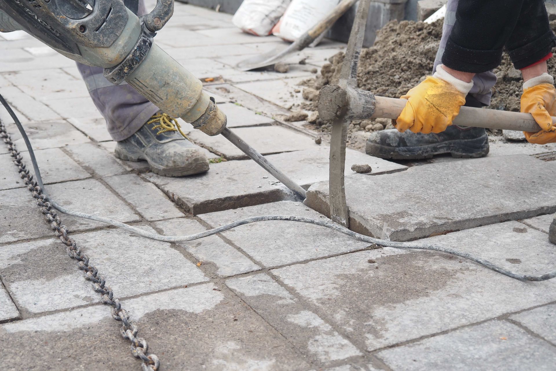 a construction worker is using a hammer to break a brick wall