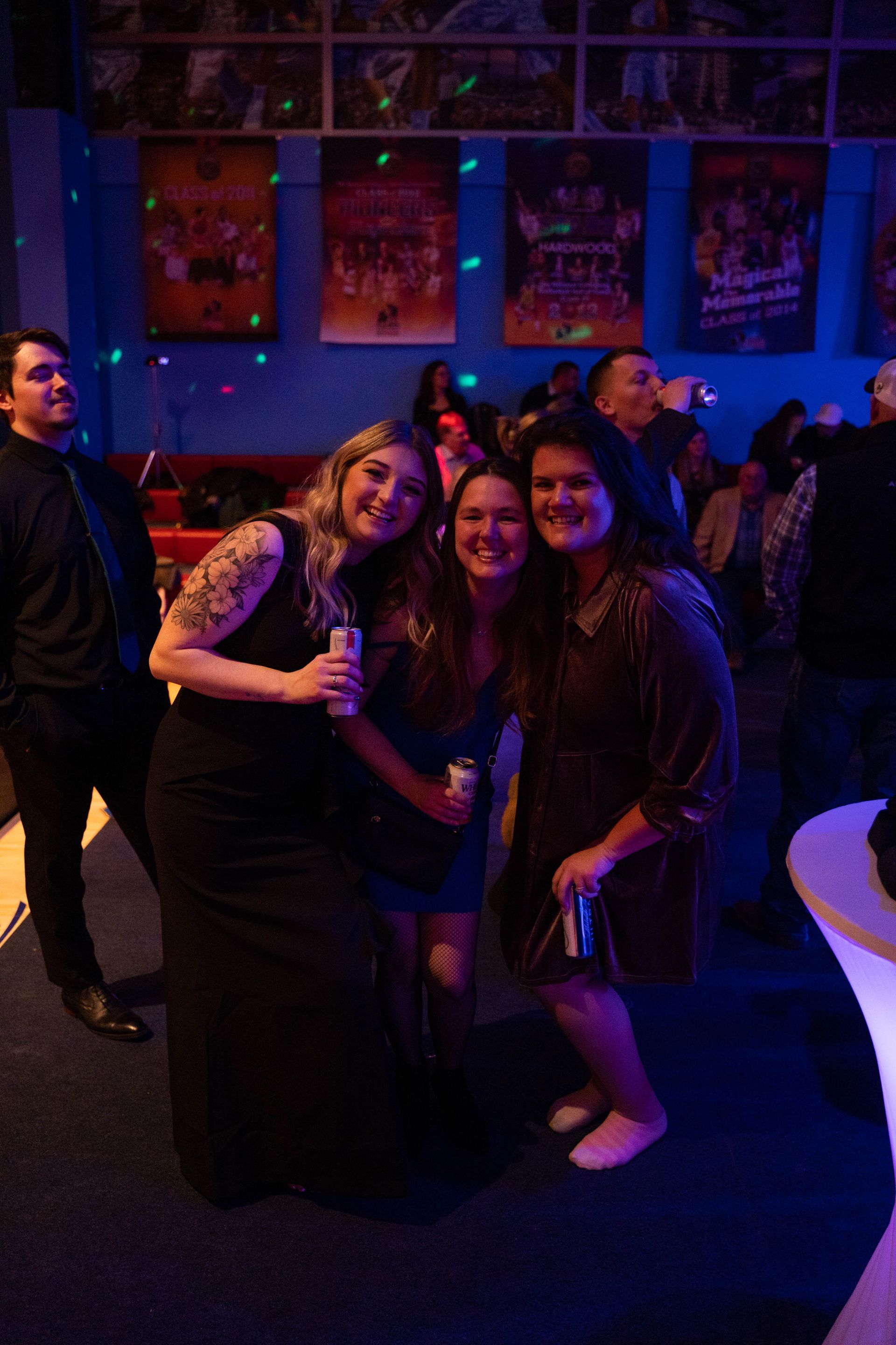 Three women are standing and smiling at the camera at the ICL 100 year anniversary party.