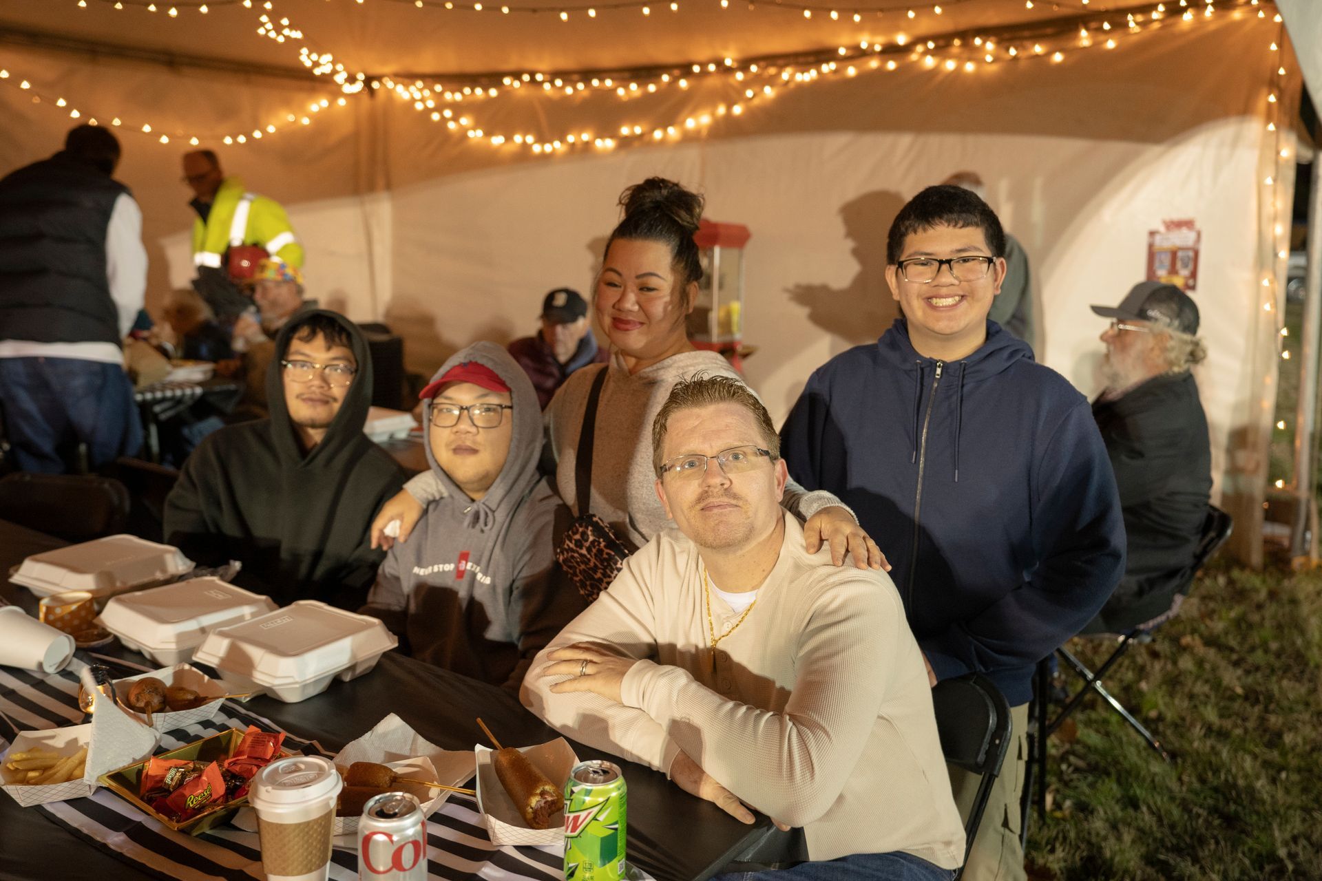 A group of people are sitting at a table under a tent.
