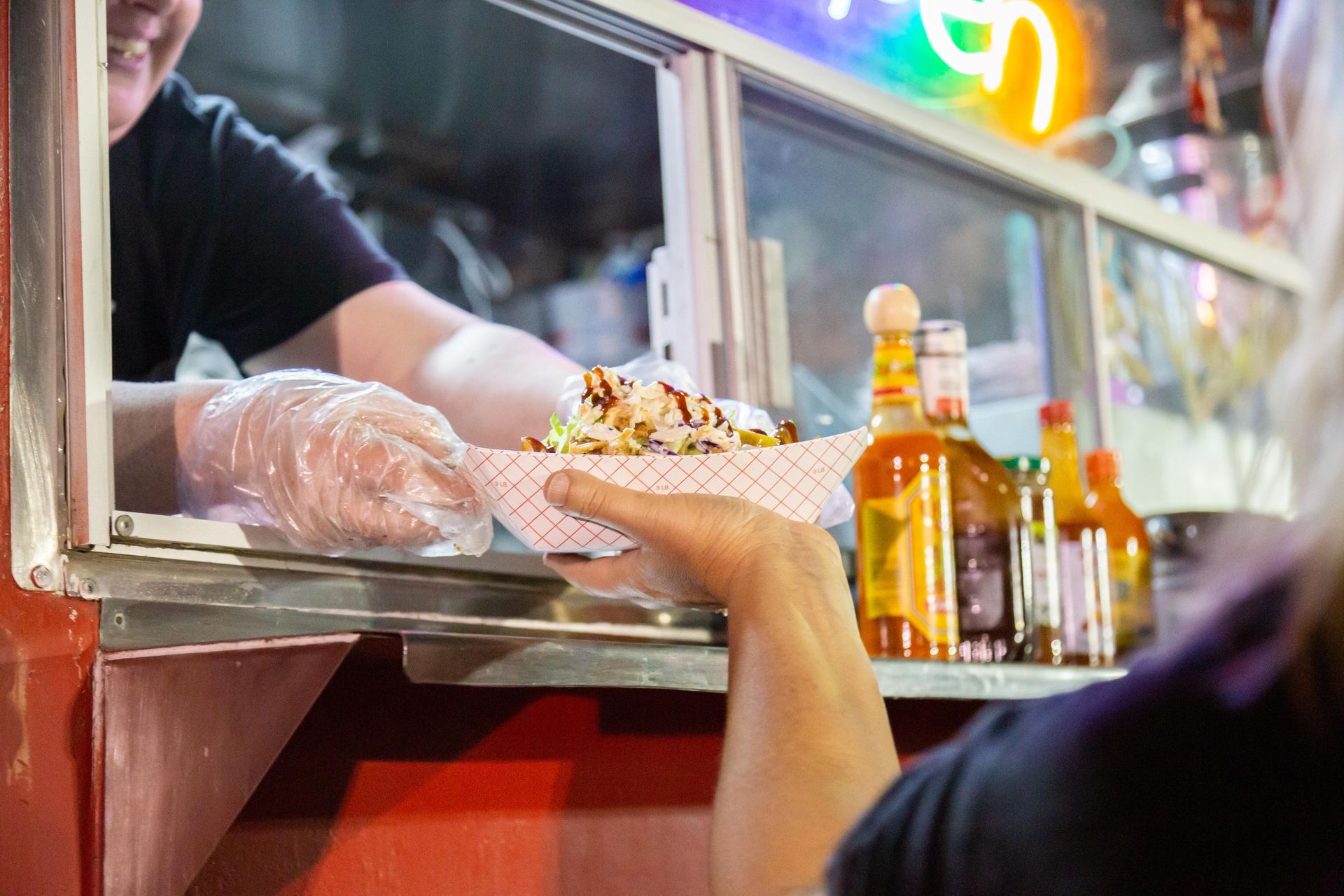 Someone receives a tray of food from the food truck.