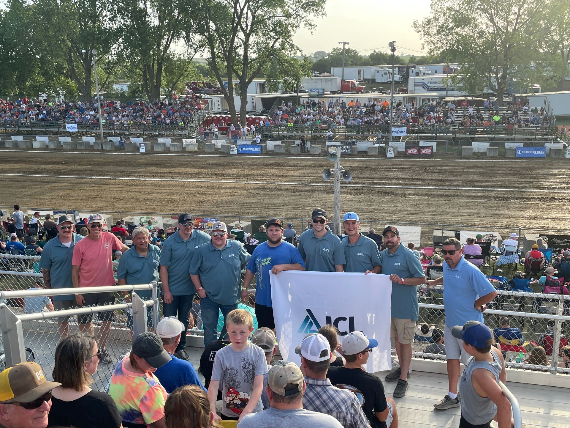 People are standing around at the Tractor Pull.