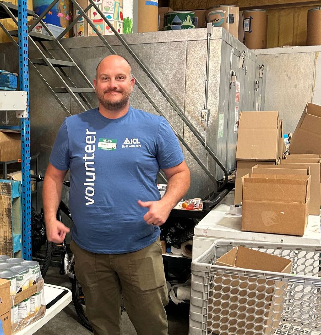 A man smiles at the camera for the food drive.
