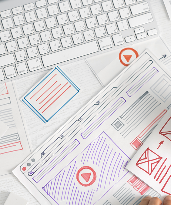 Web design wireframes sketched on paper with a keyboard in the background; a brainstorming session.