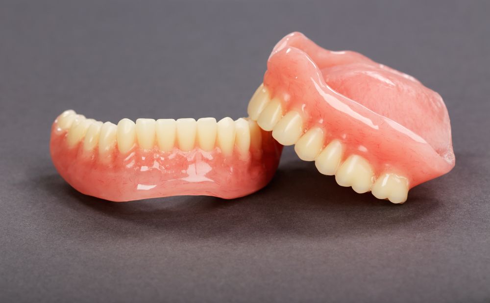 A Person Is Cleaning Their Teeth With A Toothbrush — Dentures Direct Taree-Rod Hinton In Taree, NSW