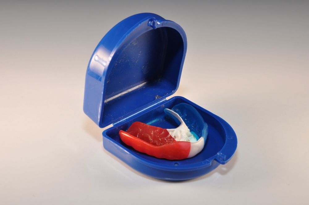 A Red White And Blue Mouth Guard In A Blue Case — Dentures Direct Taree-Rod Hinton In Port Macquarie, NSW