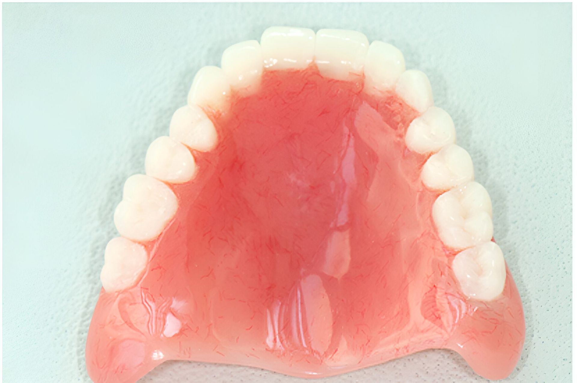 A Close Up Of A Denture With White Teeth On A White Surface — Dentures Direct Taree-Rod Hinton In Taree, NSW
