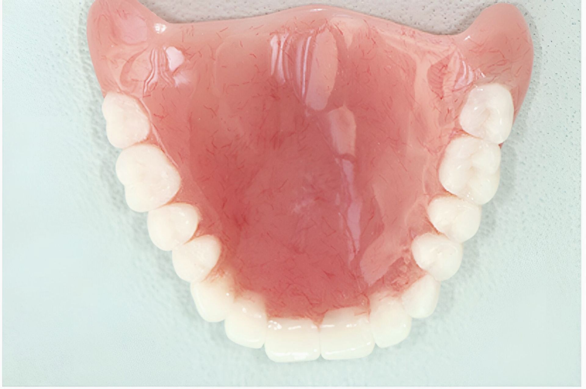 A Close Up Of A Denture With White Teeth On A Table — Dentures Direct Taree-Rod Hinton In Taree, NSW