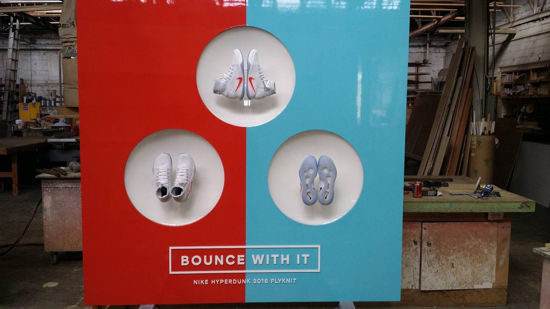 Red and blue display with shoes in circular openings. Text 