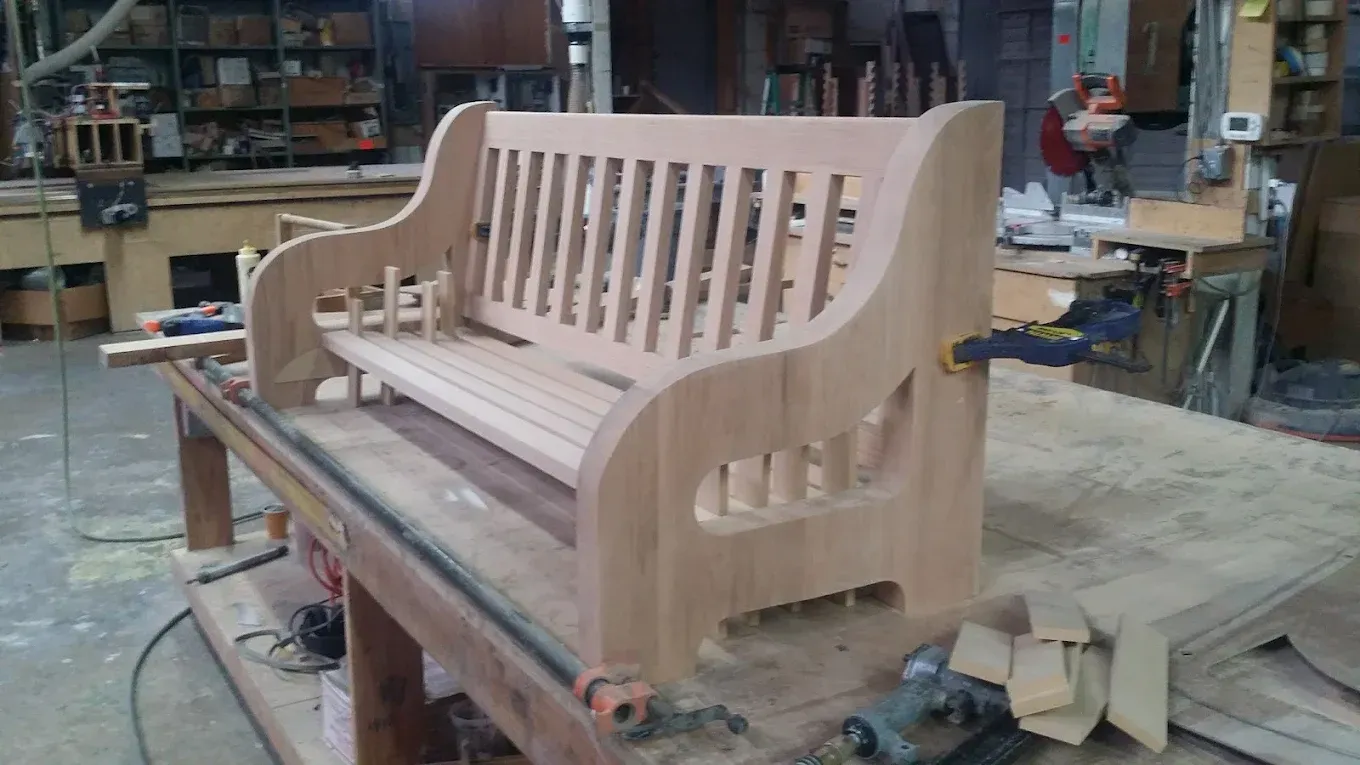 Wooden bench in a workshop, unfinished, clamped on a workbench.