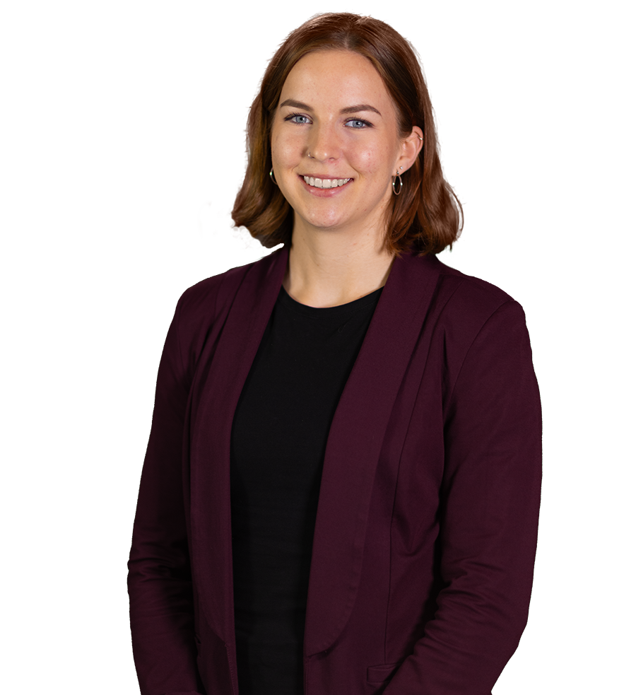Person lächelt in einem bordeauxroten Blazer über einem schwarzen Oberteil