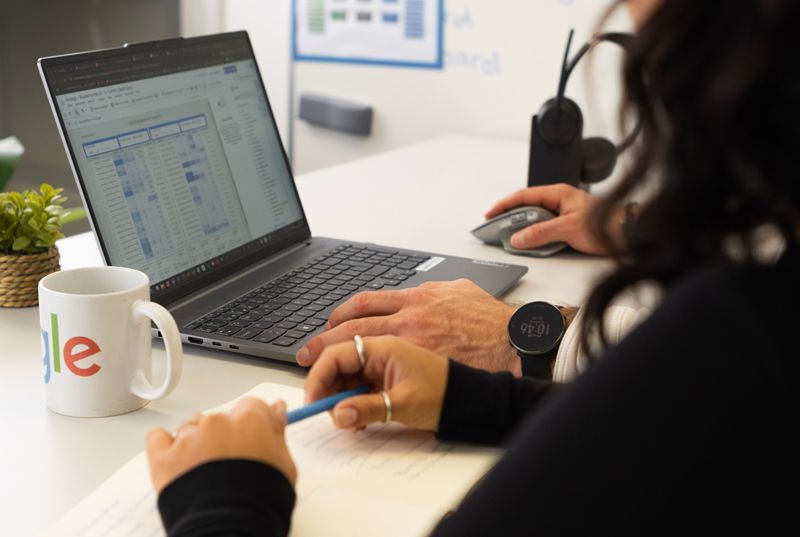 Eine Frau steht hinter einer Glasscheibe und schreibt auf gelbe Post-Its