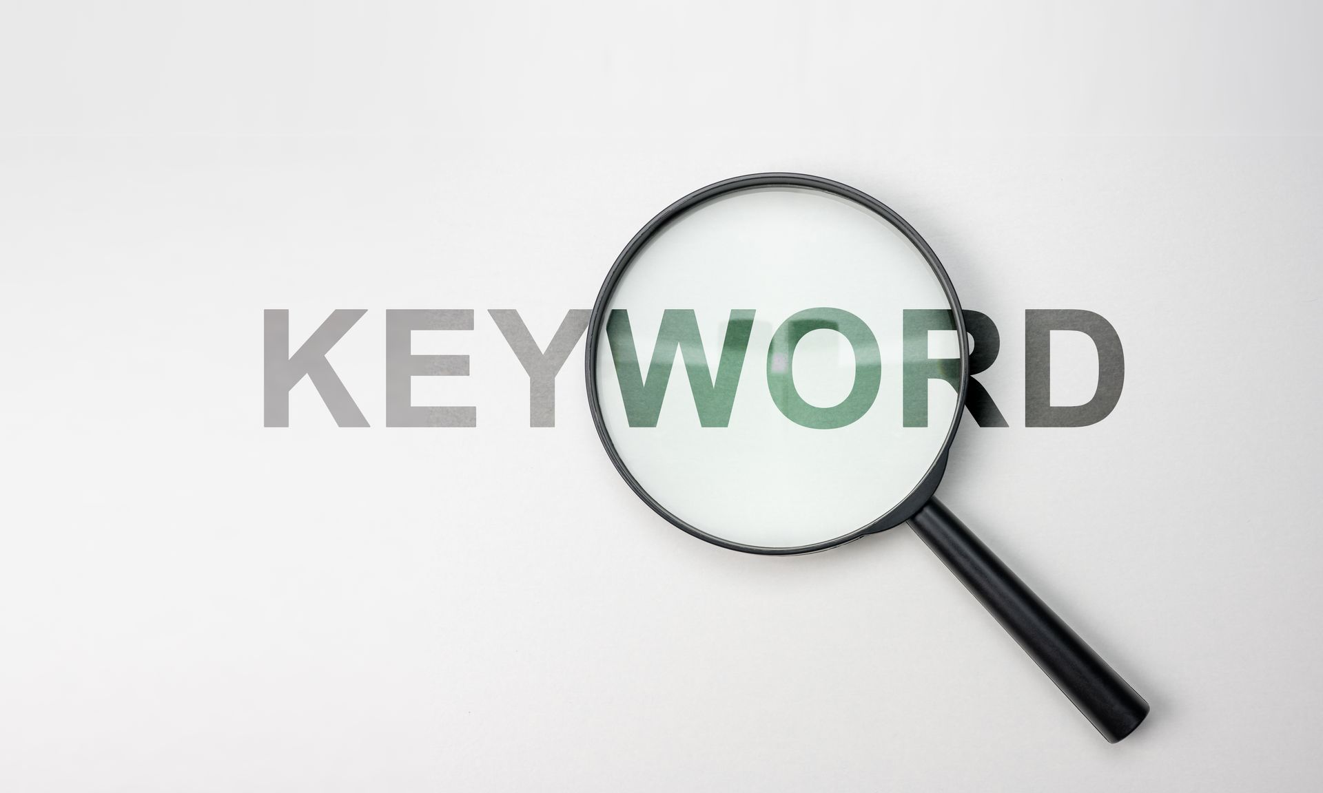 Das Wort Keyword steht auf weissem Hintergrund mit einer Lupe