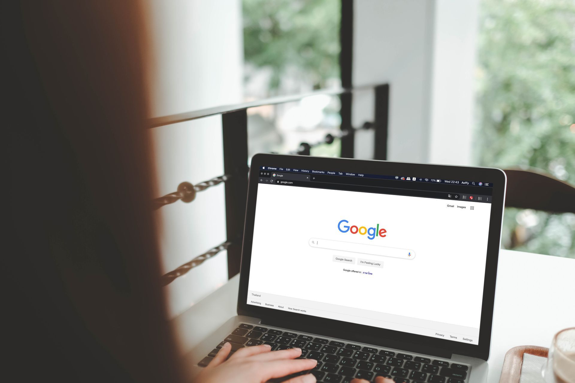 Eine Person tippt auf einem Laptop-Computer mit einer Google-Suchseite.