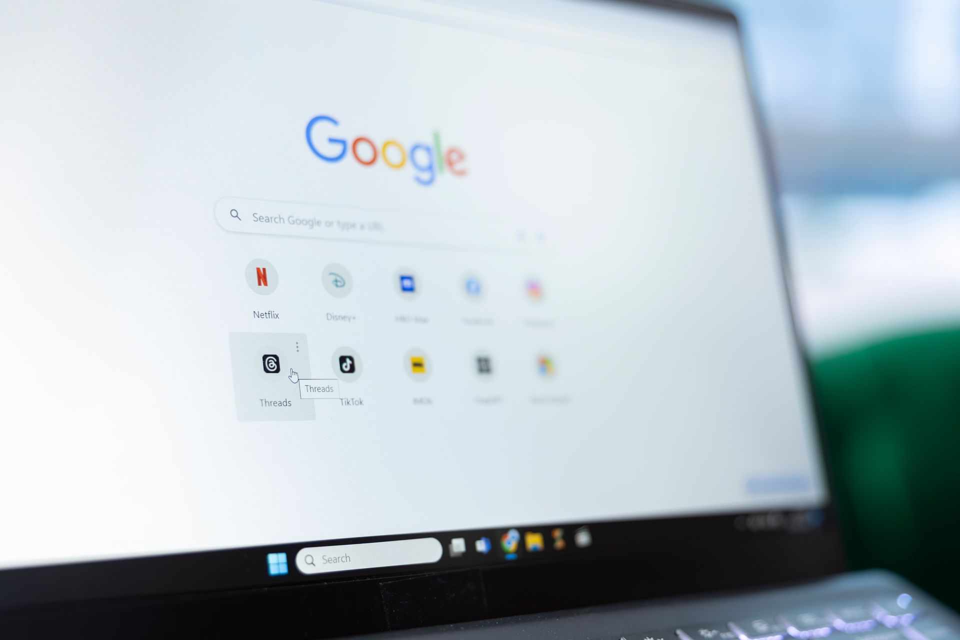 Laptop-Bildschirm, auf dem die Google-Startseite zu sehen ist, mit sichtbaren App-Symbolen und der Taskleiste