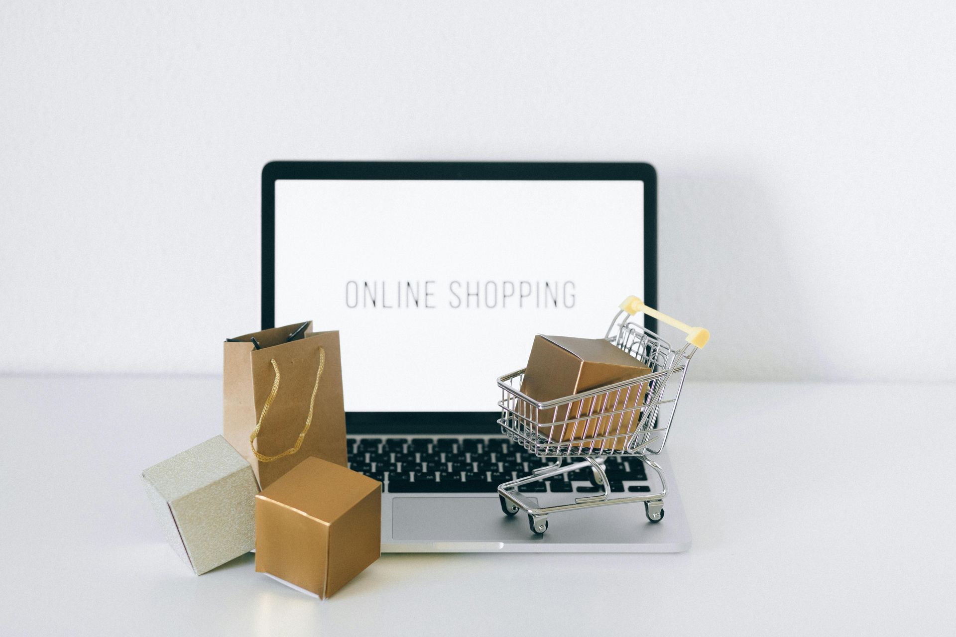Ein Laptop mit einem Einkaufswagen und Kartons darauf.