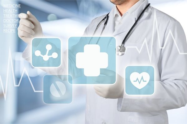 Ein Arzt im weißen Kittel berührt schwebende medizinische Symbole vor einem blauen Hintergrund aus dem Gesundheitswesen.