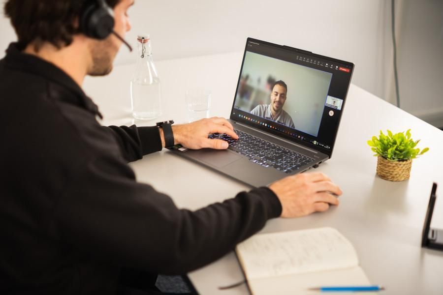 Ein Mann sitzt in einem Online-Meeting am Laptop
