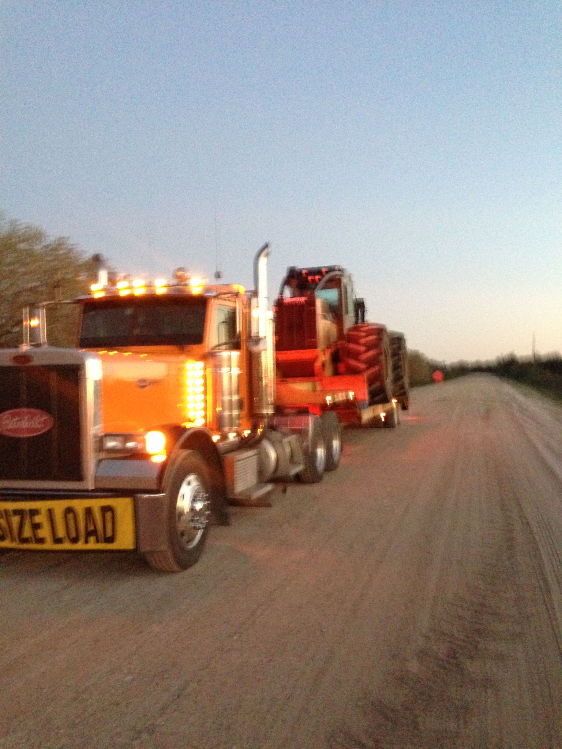 A large orange truck with a yellow sign that says size load