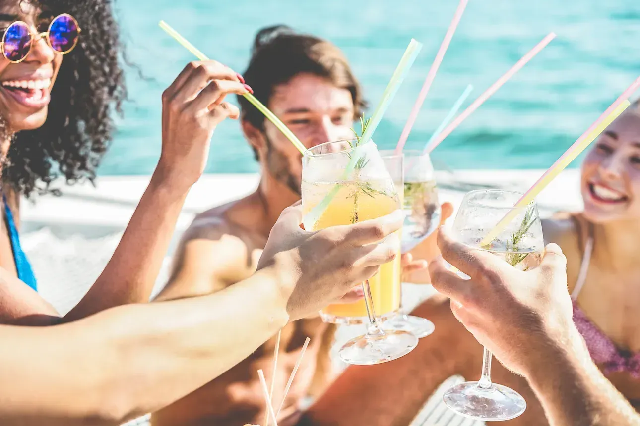 Grupo de amigos brindando con cócteles durante una fiesta en catamarán en Punta Cana.