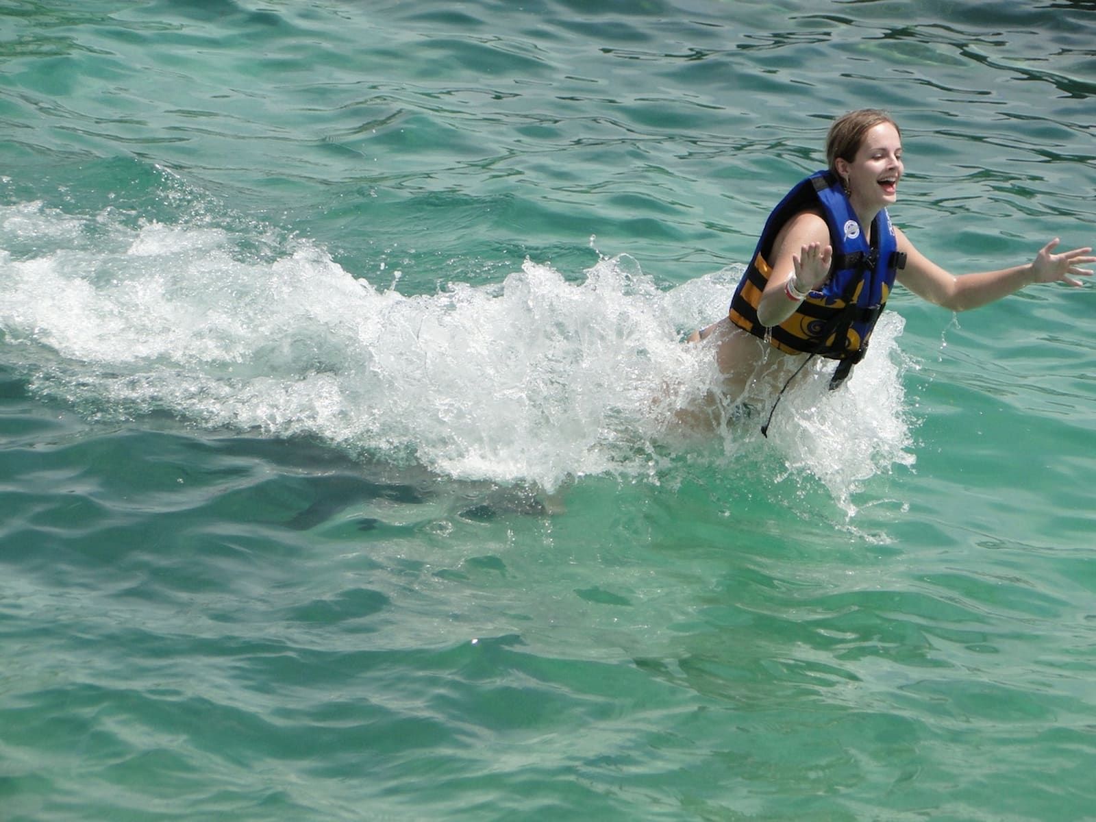 Turista disfrutando una experiencia VIP con delfines en Punta Cana, actividad guiada en el agua