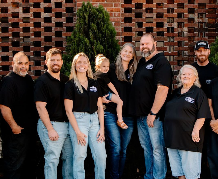 A group of people are posing for a picture in front of a building.