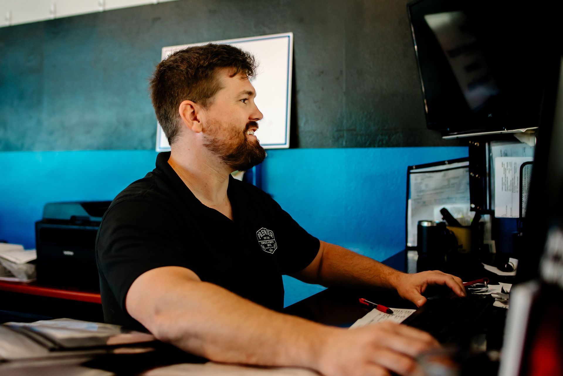 A man with a tattoo on his arm is sitting at a table.