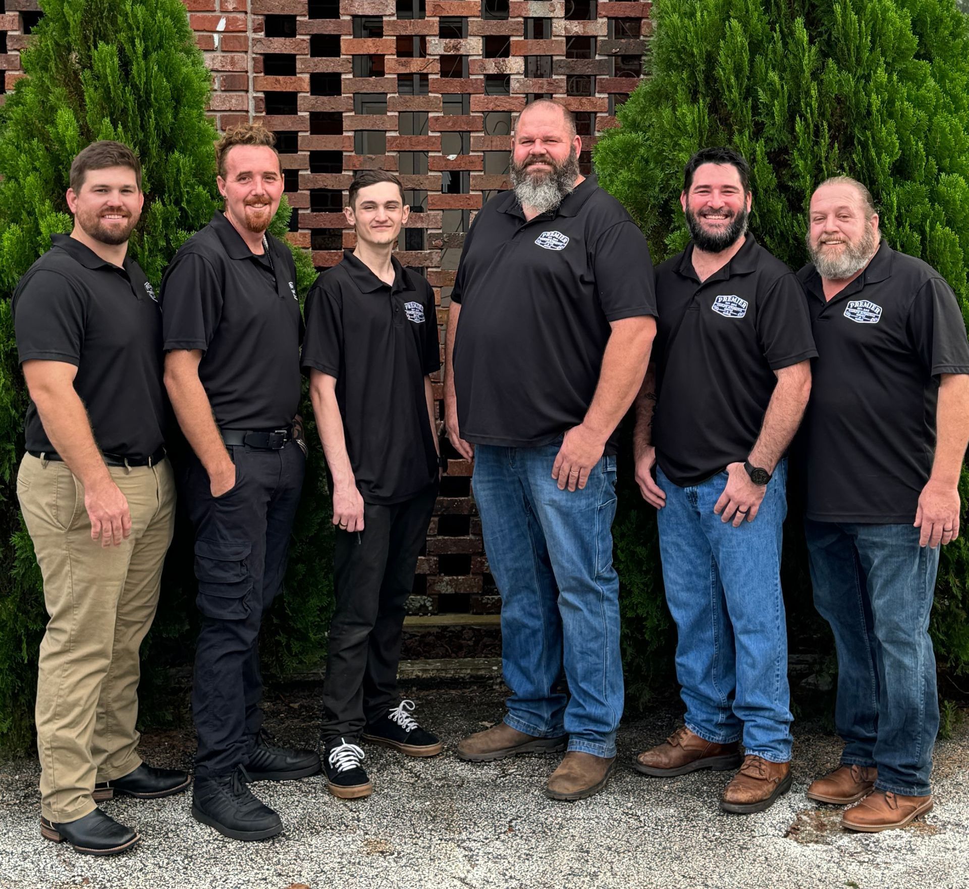 A group of men standing next to each other in front of a brick wall