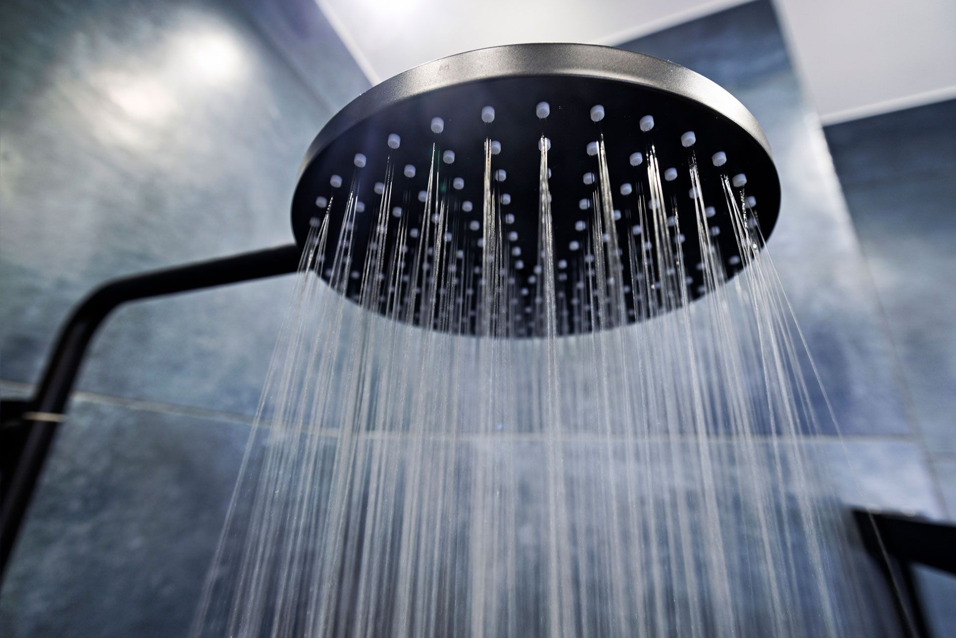 A close up of a shower head with water coming out of it.
