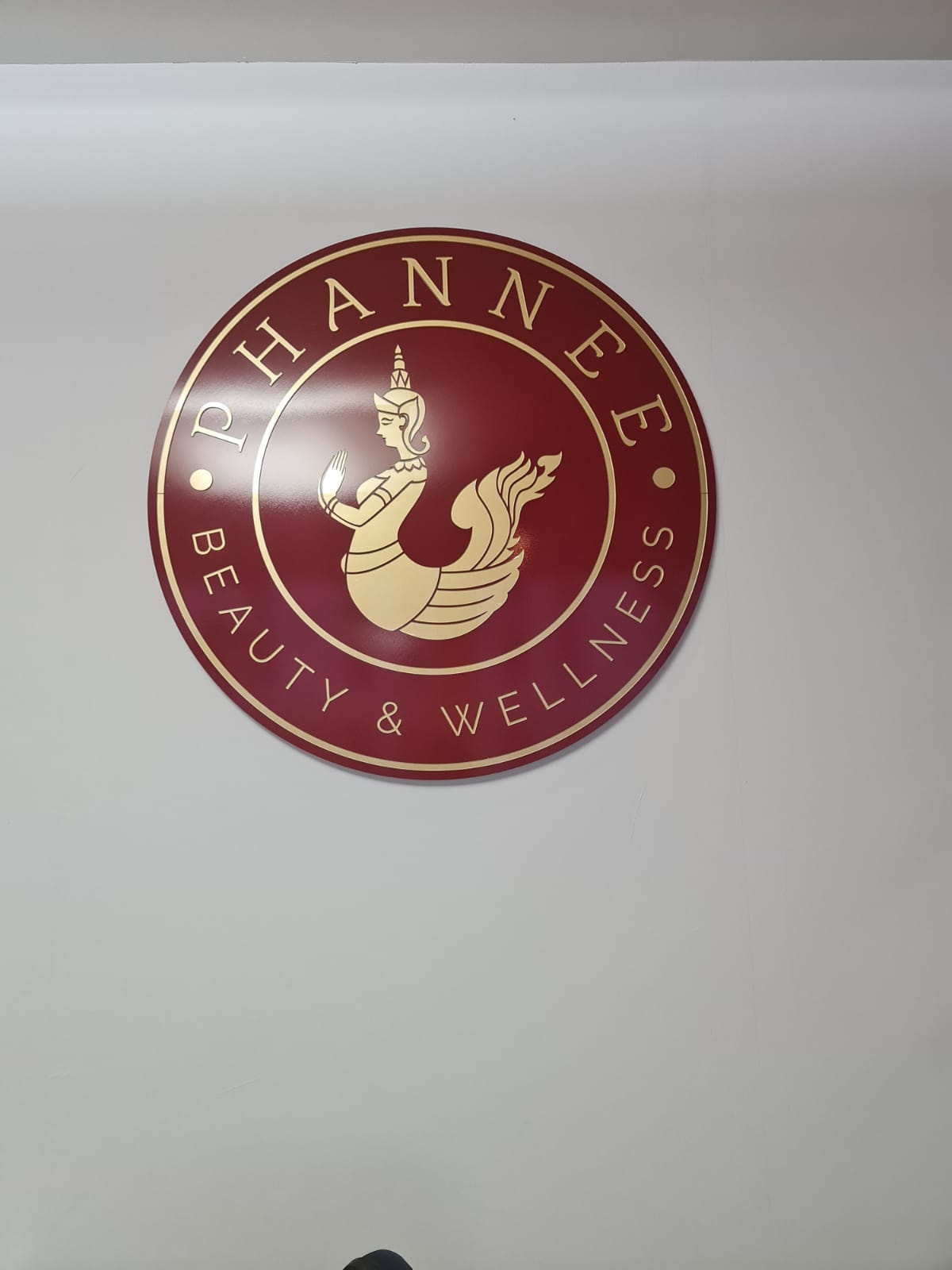 Ein rot-goldenes Schild mit der Aufschrift „Phannee Beauty and Wellness“