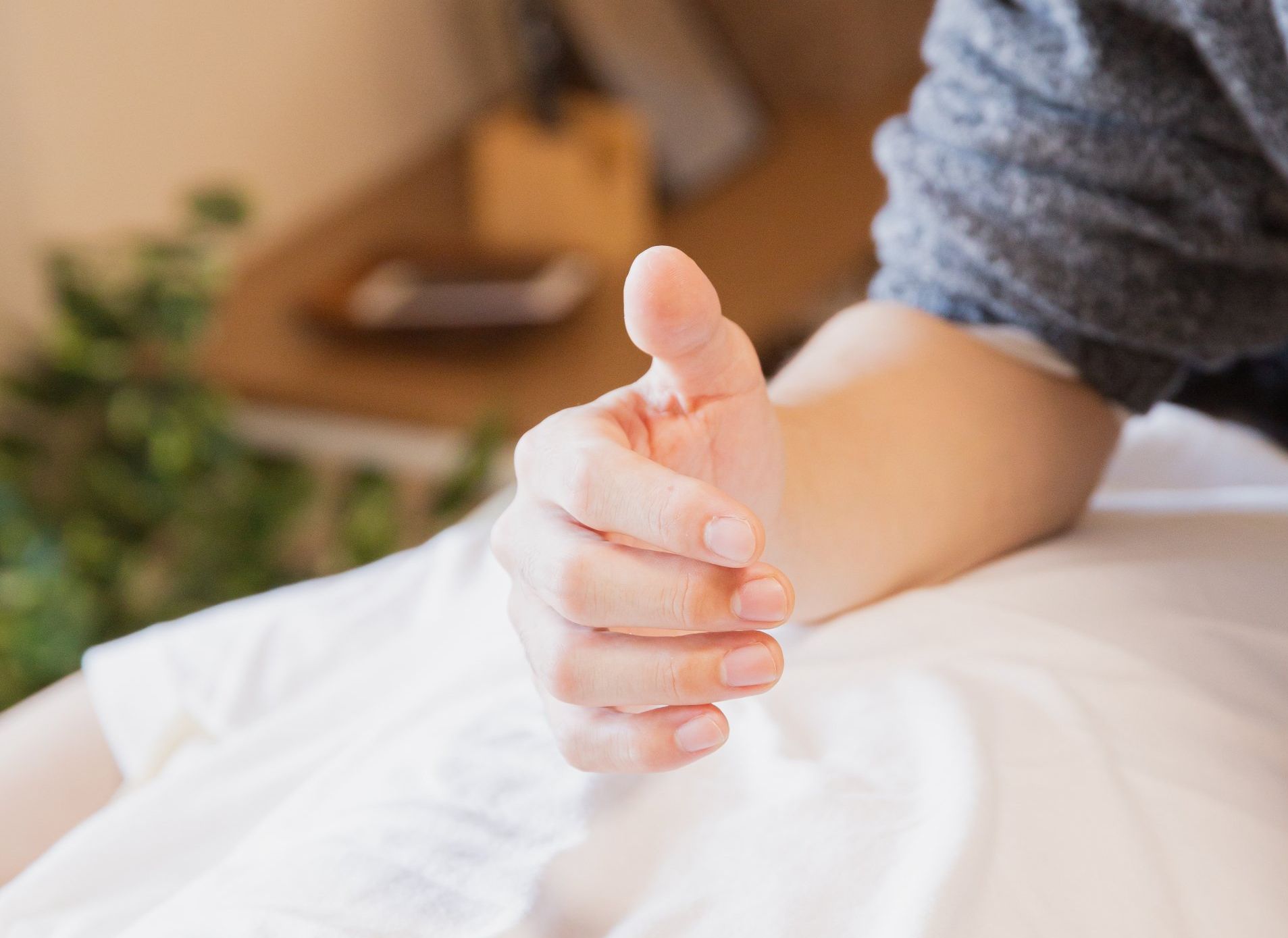 Eine Person zeigt mit der Hand den Daumen nach oben.