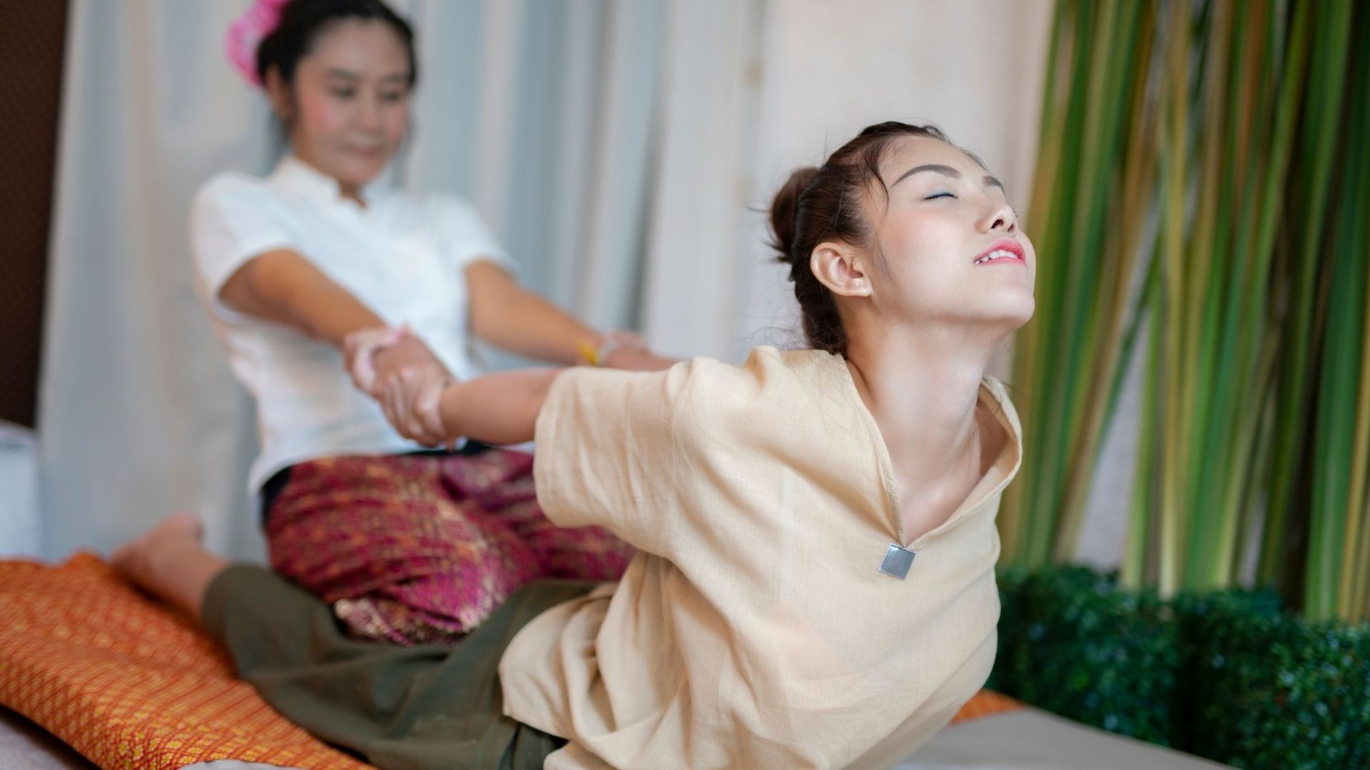 Traditionelle Thai-Massage mit typischer Dehnung von Rücken und Schulter