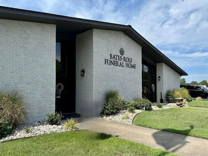 Exterior of Batesville Funeral Home with white brick walls, dark roof, and manicured lawn