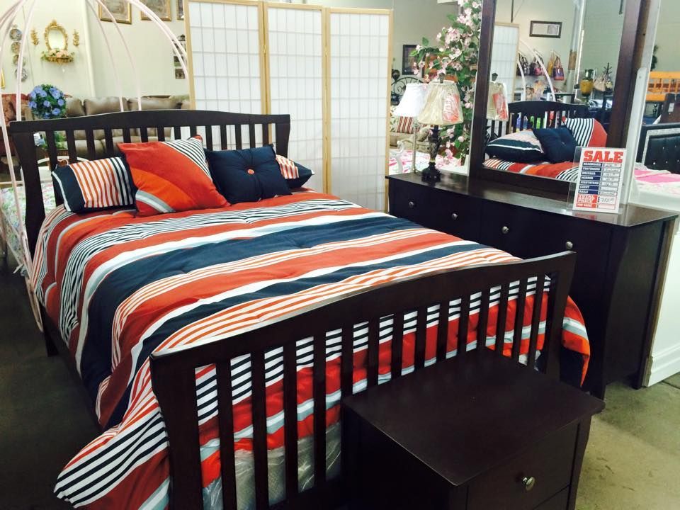 A bedroom with a bed dresser and mirror and a sign that says sale
