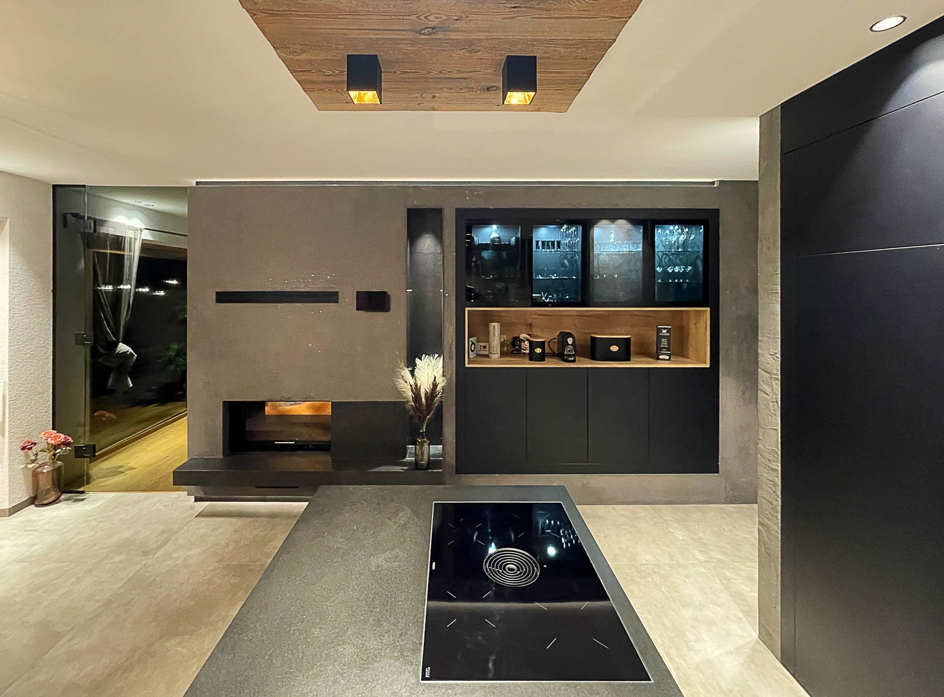Modernes, minimalistisches Wohnzimmer mit Kamin, Einbauregalen und glänzend schwarzem Boden in neutralen Farbtönen.