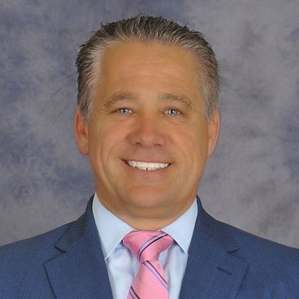 A man in a suit and tie is smiling for the camera