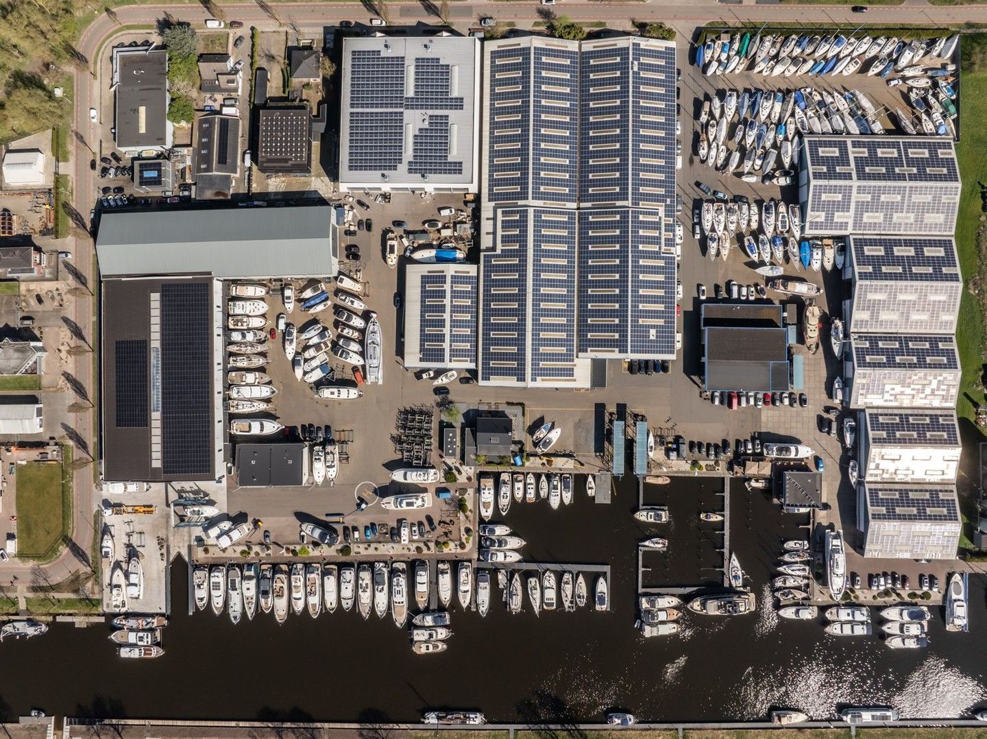 Een luchtfoto van Jachtcenter Elburg, de locatie van Yachtdetailers Elburg , u ziet een  jachthaven met boten en de halen.