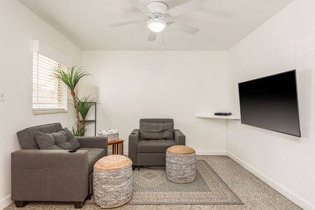 A living room with two chairs and a flat screen tv