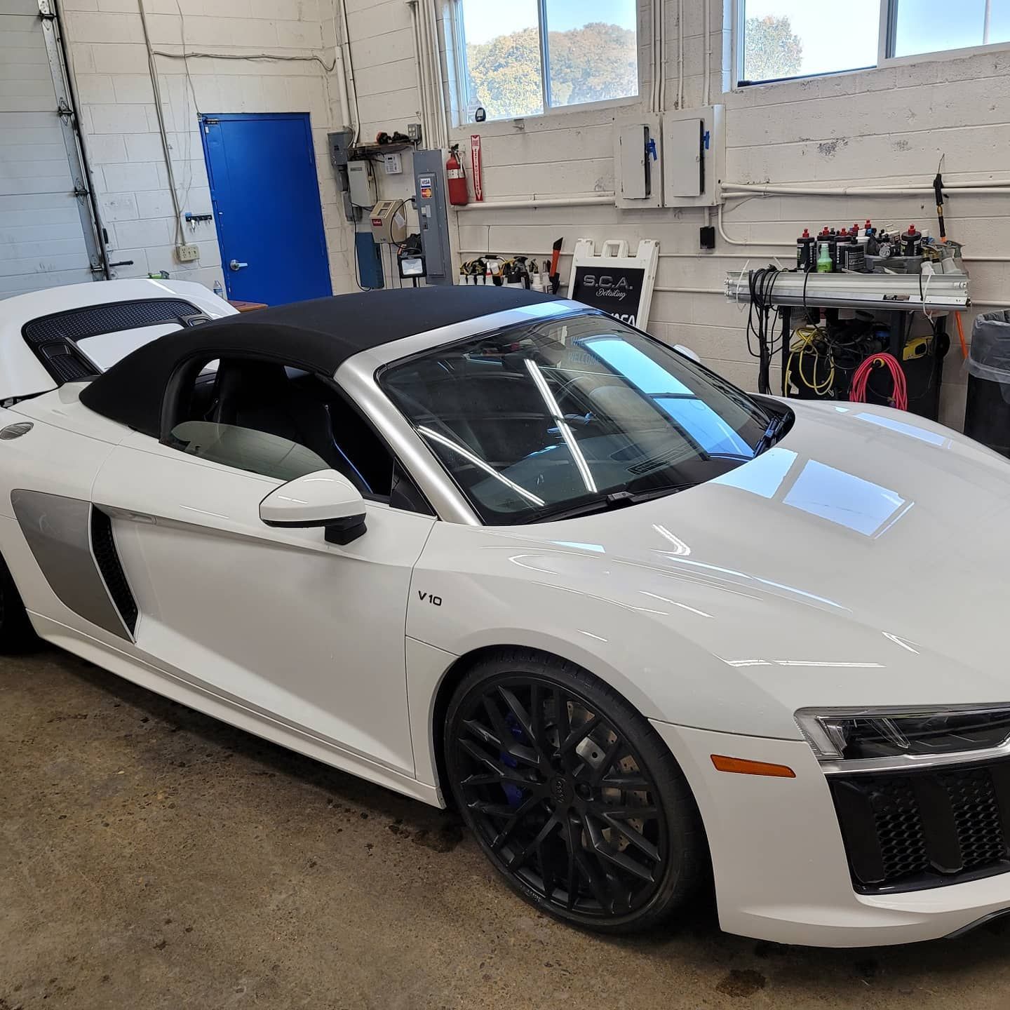 White Audi R8 Spyder convertible in a garage.