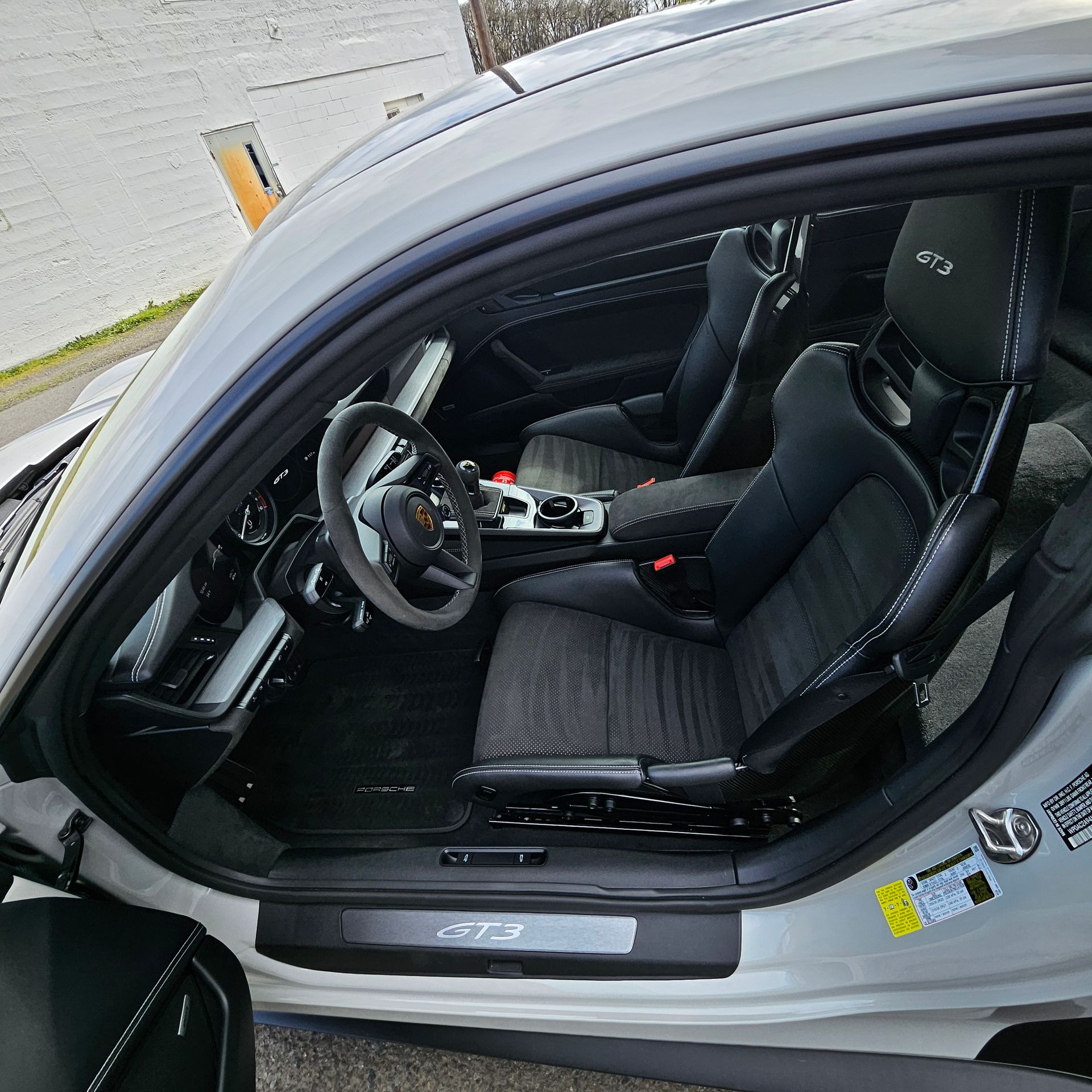 Car interior with gray rear seats, center cup holder, and orange door edge visible