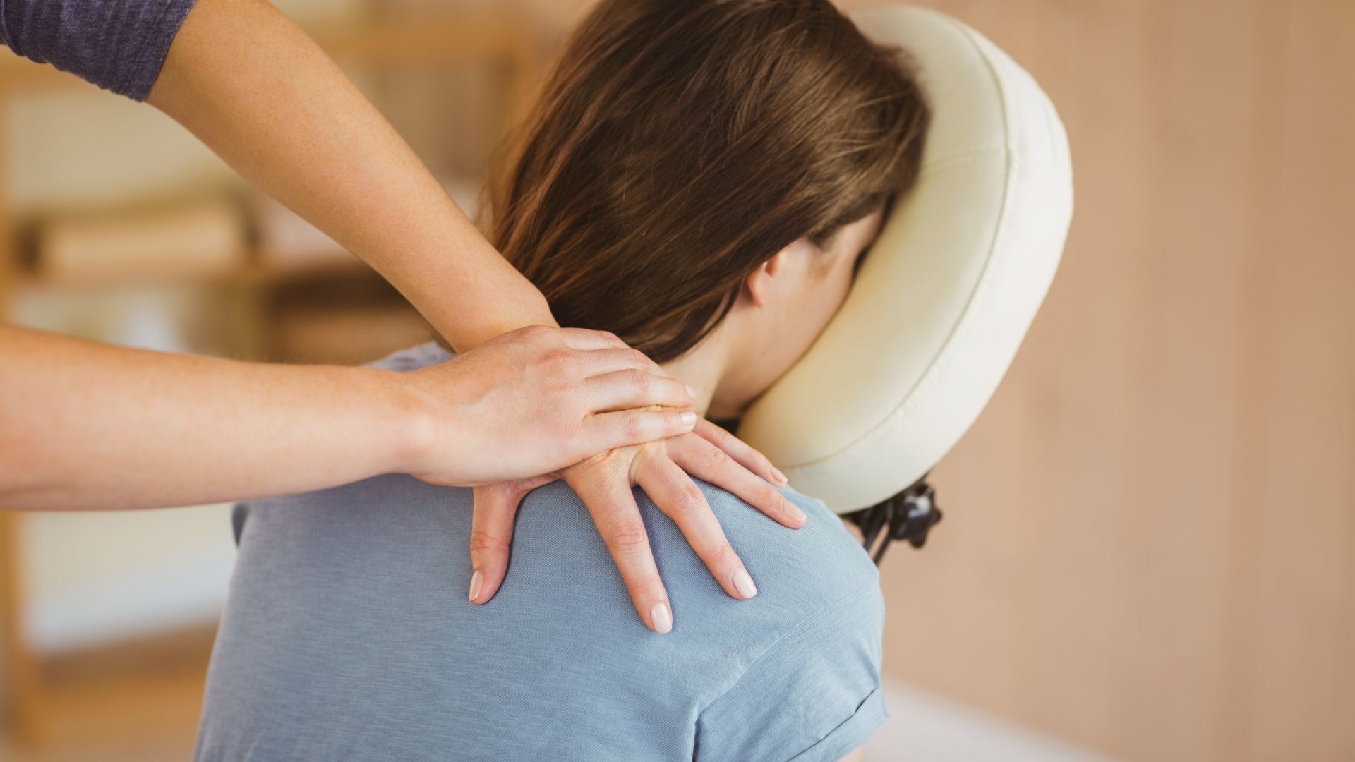 Chiropractor adjusting a patient on a treatment table in a bright clinic, legs raised upside down.