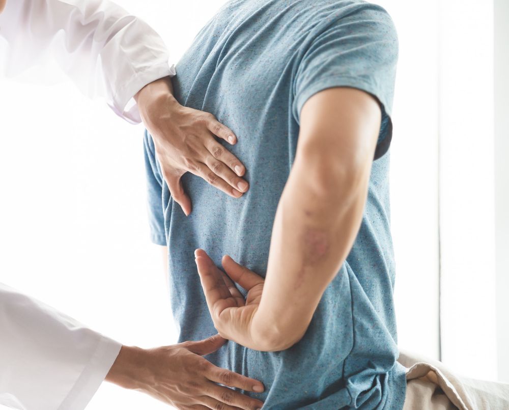 Doctor examining a patient's lower back for pain or injury