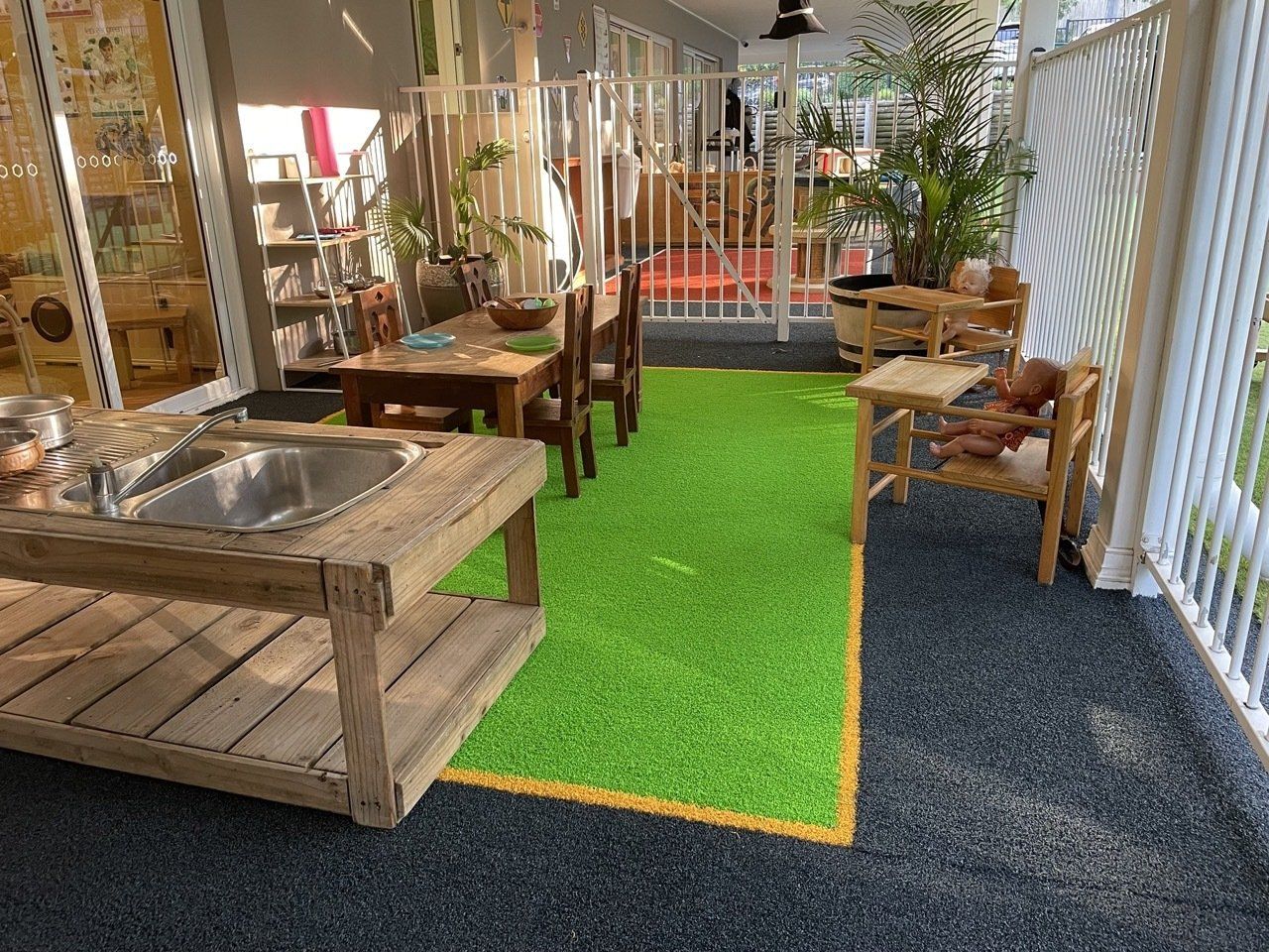 Outdoor play — Fun & Supportive Childcare Centre in Wamberal, NSW A Room With A Table, Chairs, And A Sink — Juniors At Wamberal in Wamberal, NSW