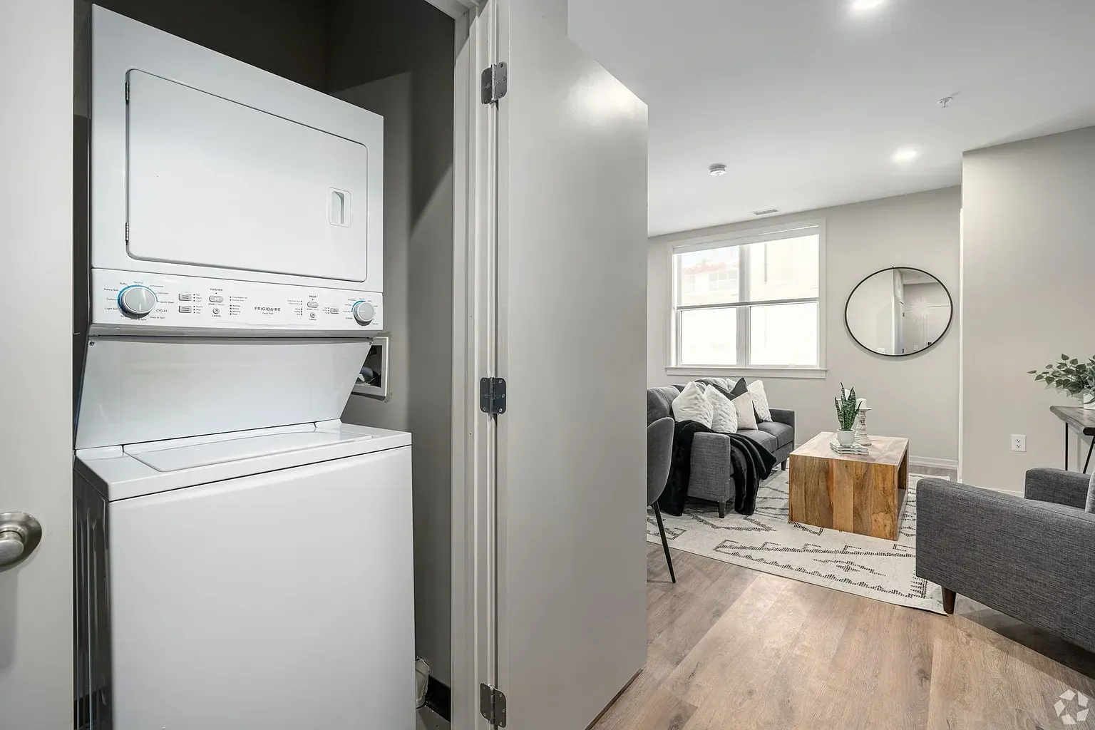 Photo of the washer and dryer area with the living room in the background