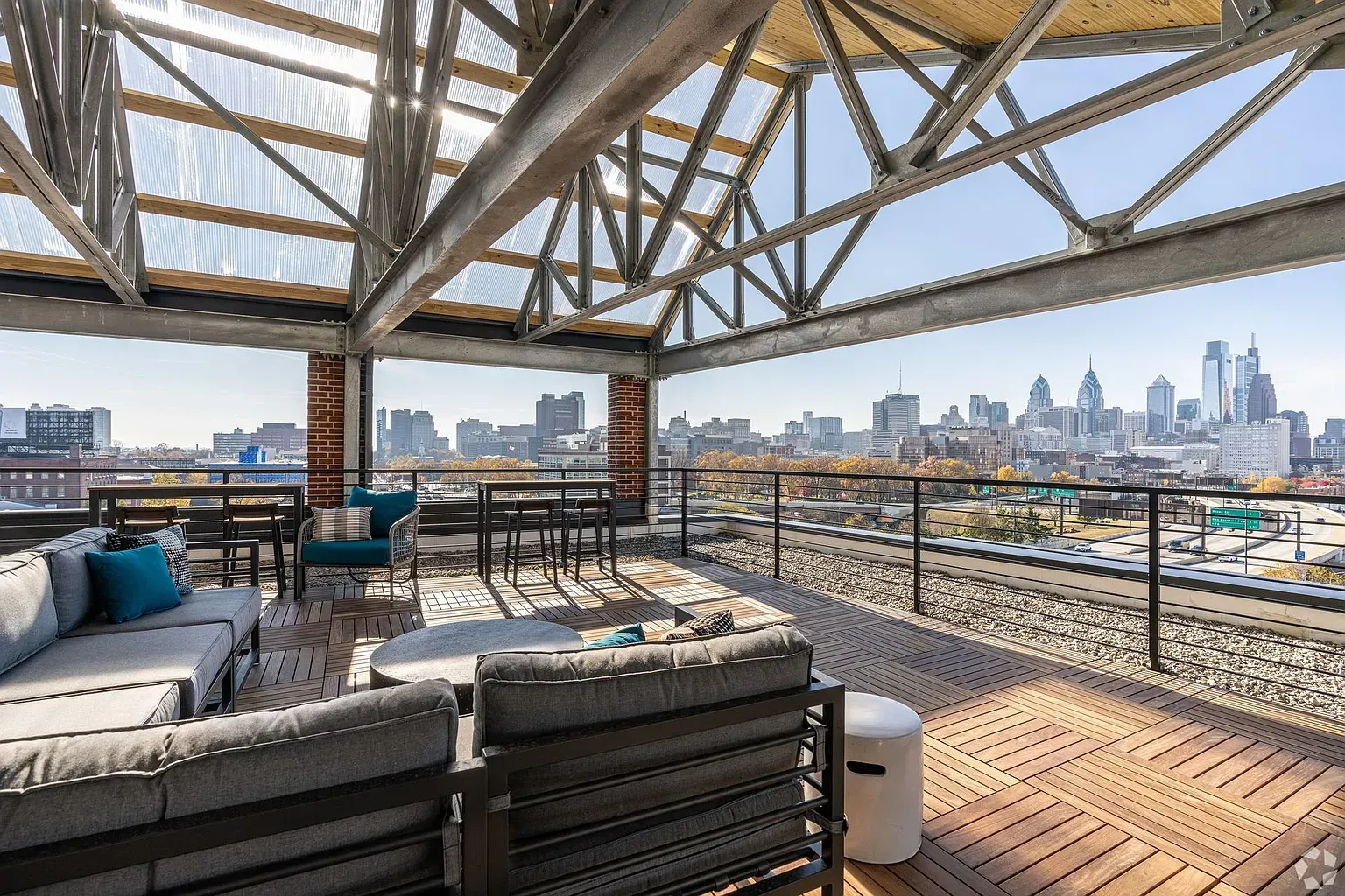 Photo of a lounge area on the rooftop deck, showing an awning, and also the skyline in the distance