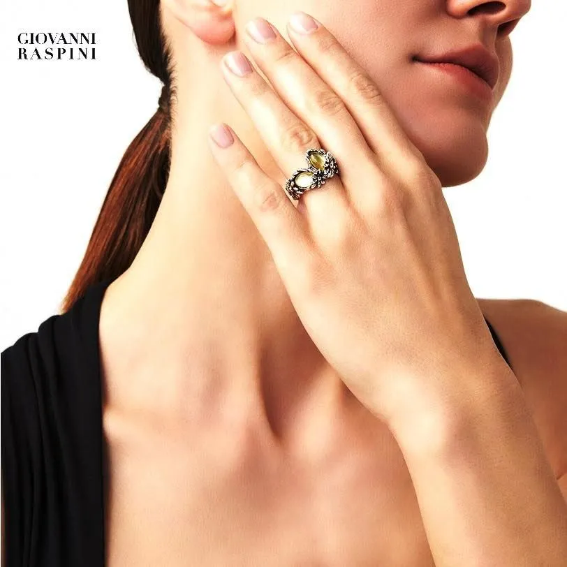 Donna che indossa un anello d'argento con pietre preziose; primo piano della mano e del collo.