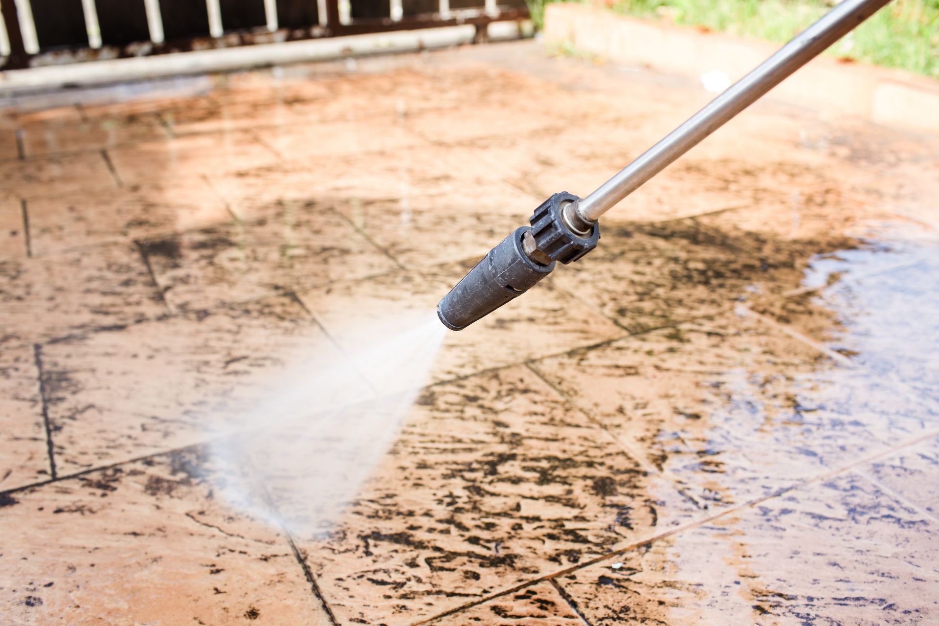 A person is using a high pressure washer to clean a concrete floor.