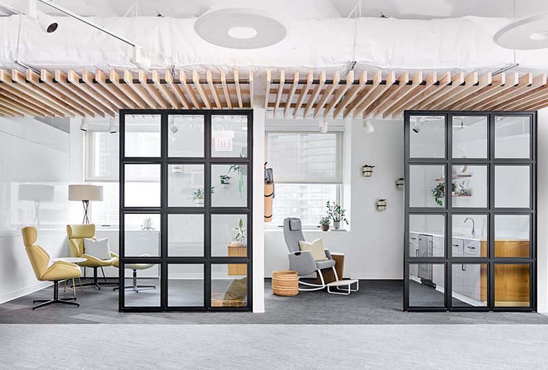 Office interior with glass-paned doors, wooden ceiling accents, and modern furniture.