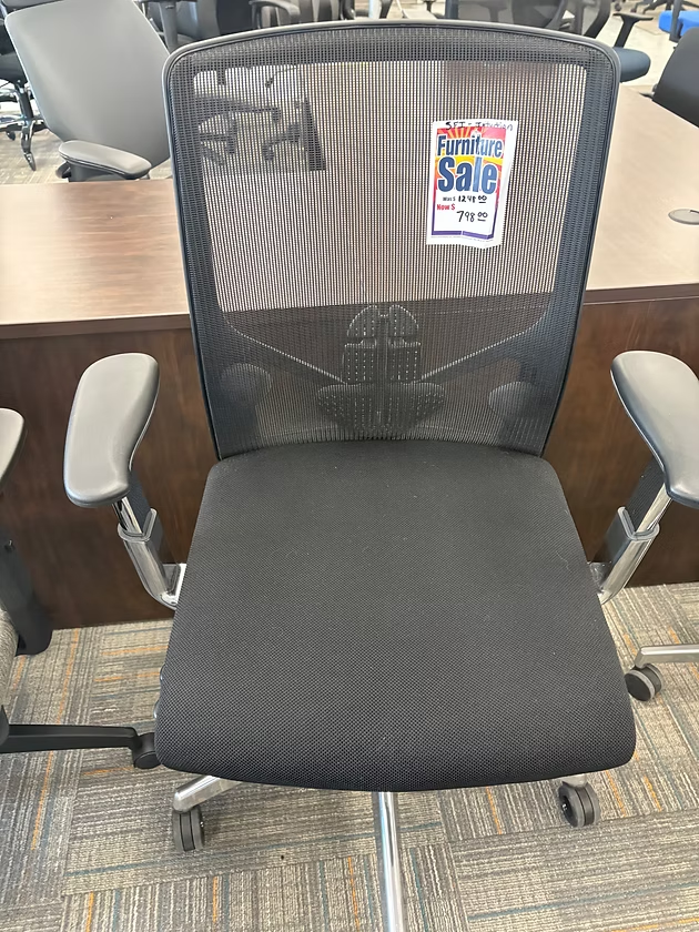 Black mesh office chair with gray arms and sale tag.
