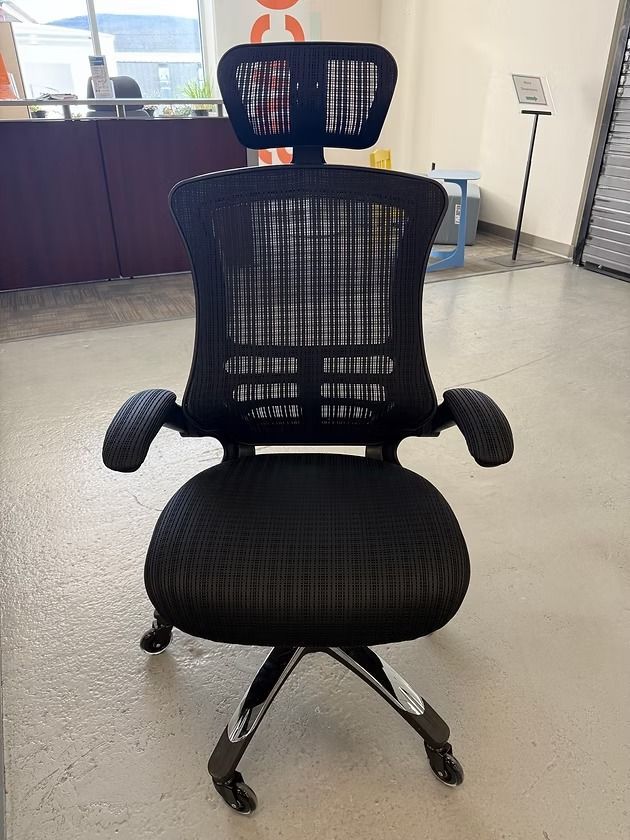 Black ergonomic office chair with headrest, mesh back, armrests, and five-star base.